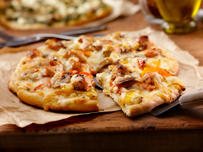 Delicious pizza with chicken and cheese on a wooden table