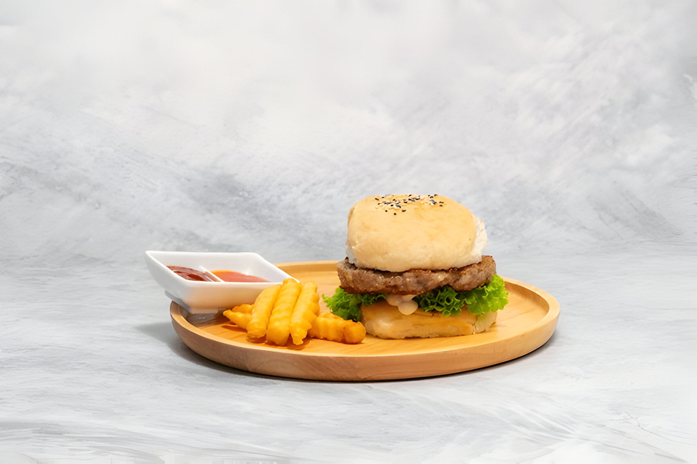 Four raw beef patties placed on a wire rack inside an air fryer.