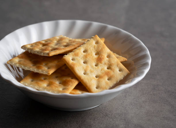 A bowl of crackers placed on a gray surface