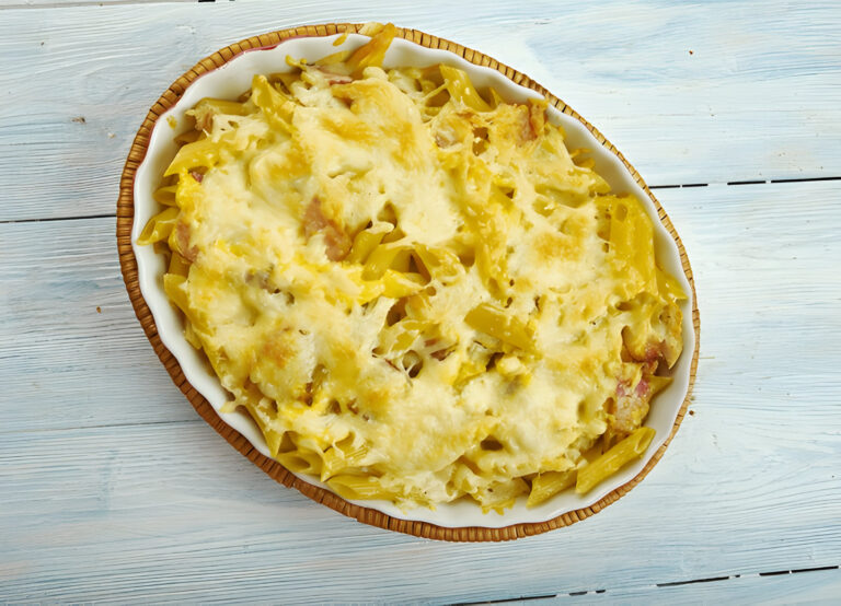 Baked pasta dish with melted cheese on top in a decorative oval dish