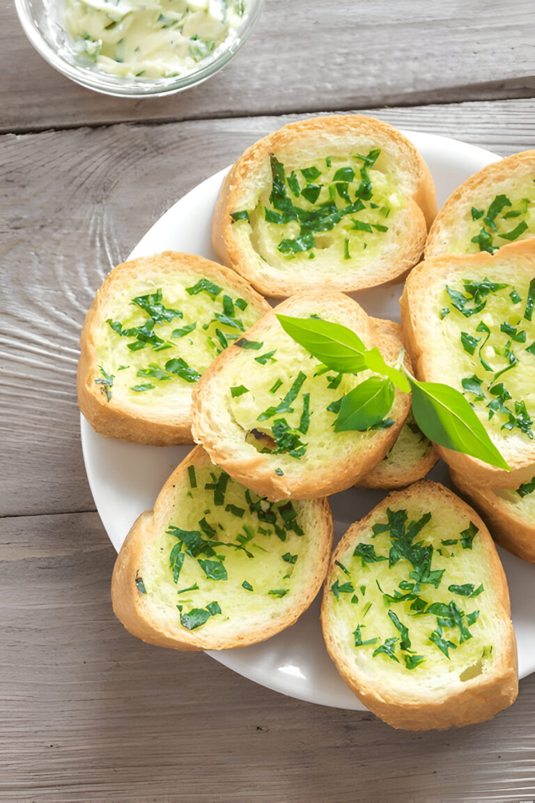 Slices of bread topped with chopped herbs on a white plate