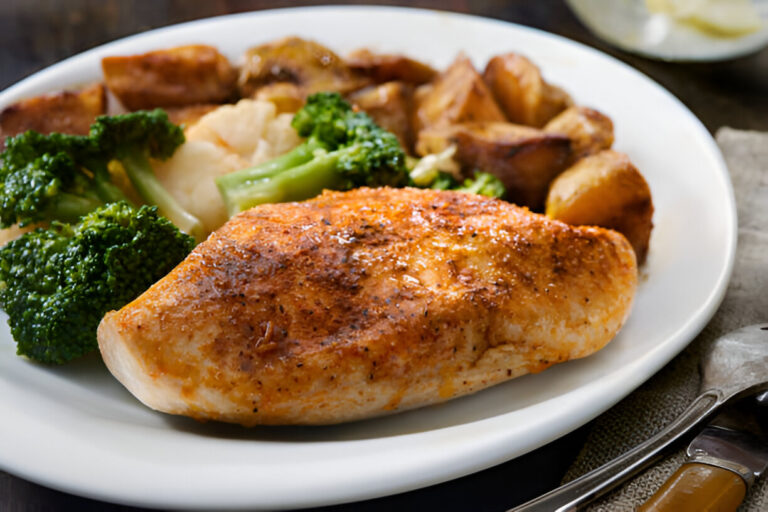 A plate of grilled chicken breast served with broccoli and roasted potatoes.
