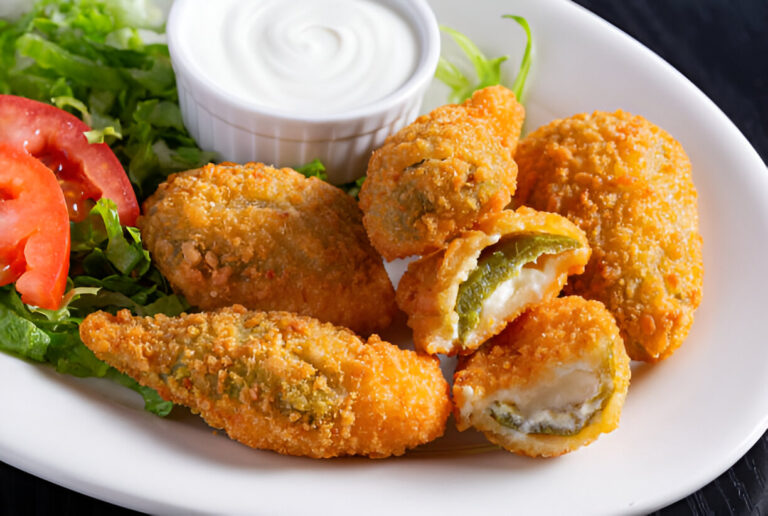 Plate of crispy jalapeño poppers with ranch dip and a side of fresh salad