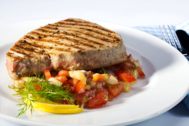 Grilled tuna steak served on a bed of fresh tomato salsa with lemon and herbs.